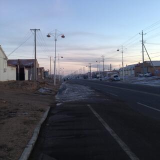 Low rise buildings sit behind undeveloped yards.