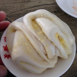 Moist white pancakes spread with a yellow substance and folded into pockets .