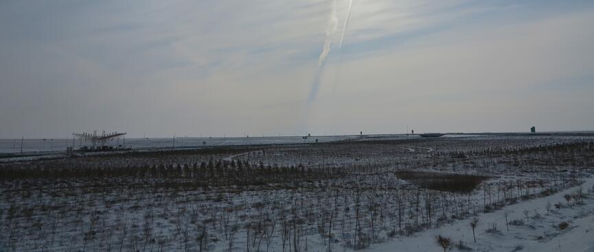 A shallow v-shaped roof covers a toll booth and the far side of a snowy field.
