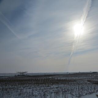 A shallow v-shaped roof covers a toll booth and the far side of a snowy field.