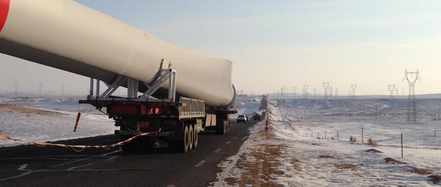 The passing truck pulls away revealing a red strip on the end of the object which is much longer than the trailer carrying it.