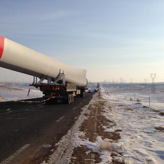 The passing truck pulls away revealing a red strip on the end of the object which is much longer than the trailer carrying it.