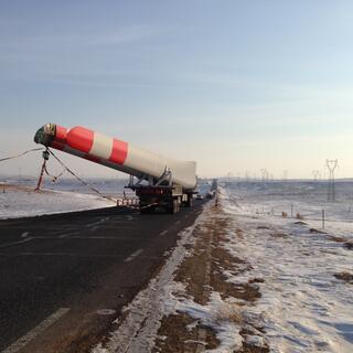 The truck continues on and the object is revealed as part of a wind turbine.