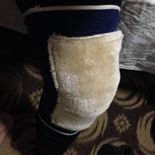 A knee-shaped rectangle of cream coloured fur on a stretchy blue backing.
