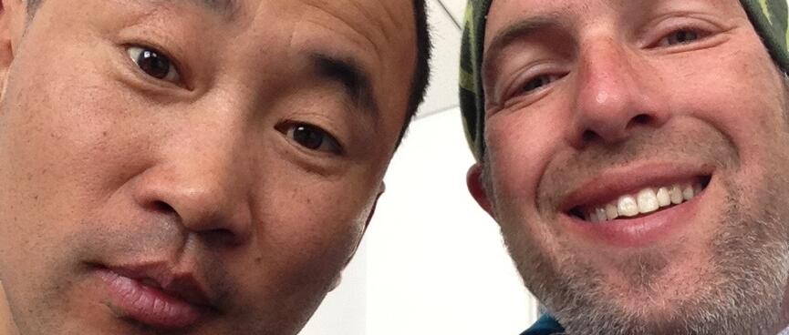 Smiling, I pose with a Chinese man with short black hair who looks quizically at the camera.