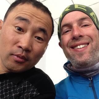 Smiling, I pose with a Chinese man with short black hair who looks quizically at the camera.