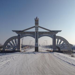 Two-lane gateway with quarter wagon wheels on either side.
