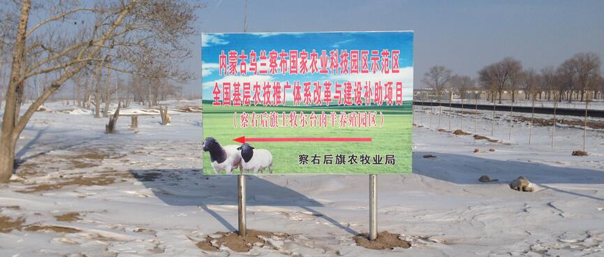A sign board shows two white sheep with black heads and necks.