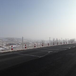 A line of orange and white road cones on the side of the road.