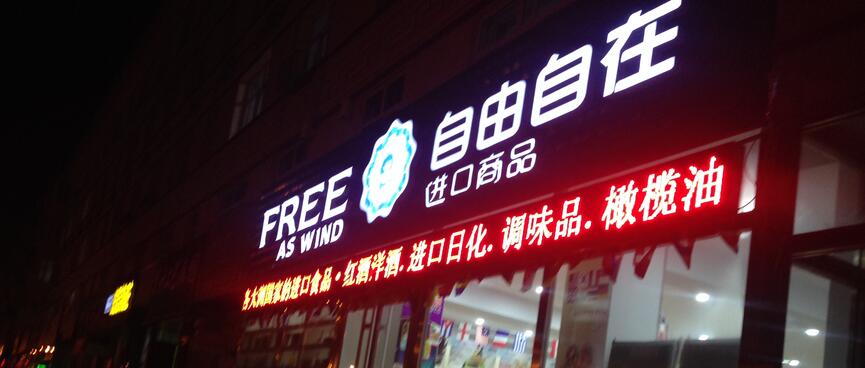 A large illuminated sign, the English portion reads Free as wind.