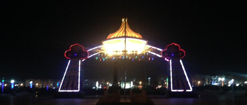A large archway is outlined in white and red neon.