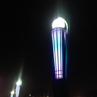 Tall illuminated torches coloured purple blue and white.