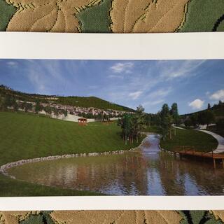 Brochure page showing modern low rise apartments on the grassy bank above a round lake.