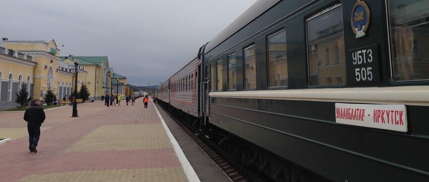 A long train parked outside the railway station.