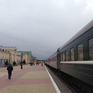 A long train parked outside the railway station.
