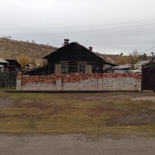 The brick wall in front of a house is half red and half grey.