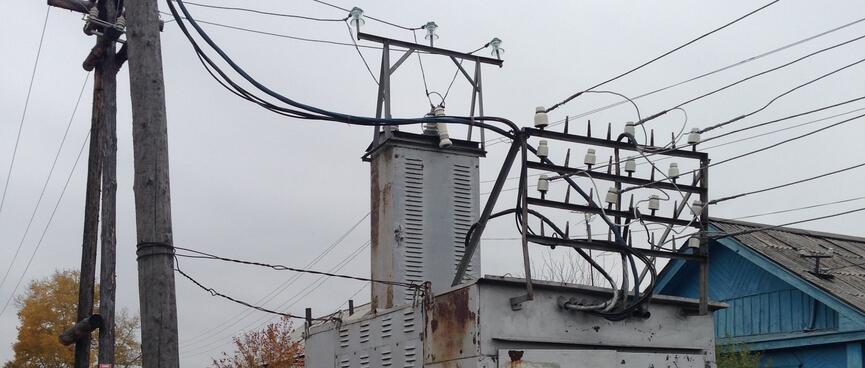 Cables run in and out of a battered grey metal shed.