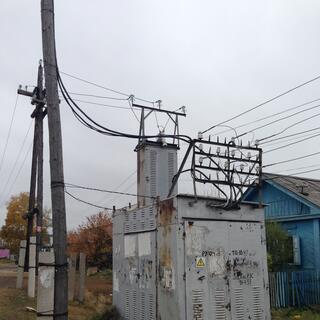 Cables run in and out of a battered grey metal shed.