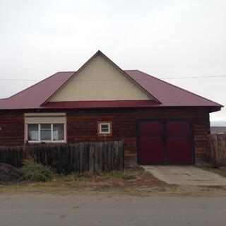 A houseʼs roof is painted crimson but its gables are cream.