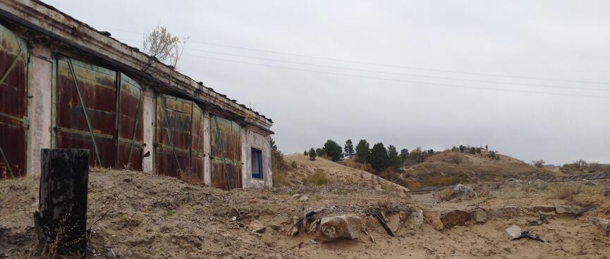Rocks and sand outside a shuttered store house.
