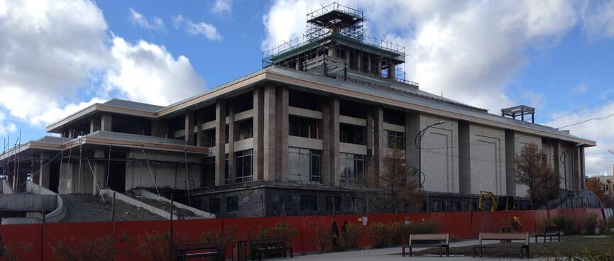 An imposing three story stone building surrounded by scaffolding.