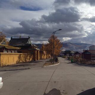 Snow dusted mountains tower above apartment blocks and temples.