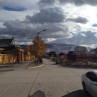 Snow dusted mountains tower above apartment blocks and temples.
