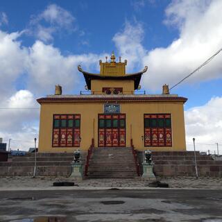 Muddy yellow temple with upturned eaves.