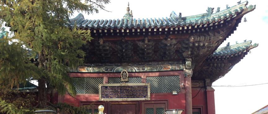 Crimson single story building with ornate upturned wooden eaves.