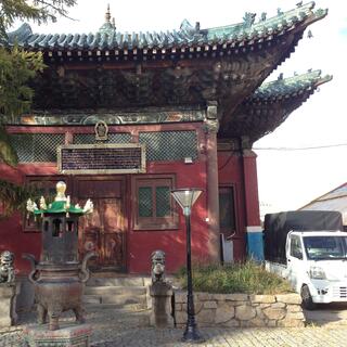 Crimson single story building with ornate upturned wooden eaves.