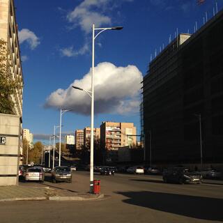 A puffy white cloud hangs above a set of completed apartment blocks and scaffolding around new development.