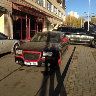 A dusty black car with contrasting red trim.