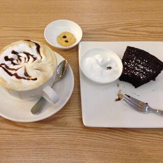 A cup of mocaccino and a slice of brownie with yoghurt.