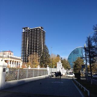 Rectangle and circular high rises soar above low rise buildings.
