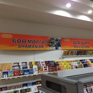 Two halves of a book shelf are signposted with ʼShamanismʼ and ʼReligionʼ.