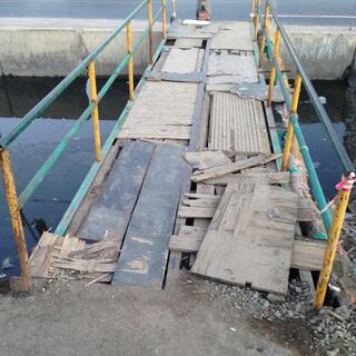 Loose bits of wood cover the metal bones of a pedestrian bridge.