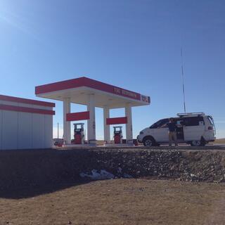 White buildings with red trim at a petrol station.