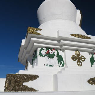 A stone monument is adorned with golden swirls and the figure of a white lion.