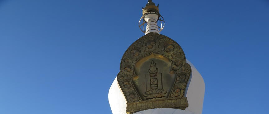 A plaque at the top of a stone monument features geometric shapes, and a yin and yang symbol.