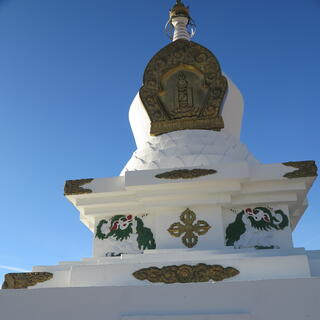 A plaque at the top of a stone monument features geometric shapes, and a yin and yang symbol.
