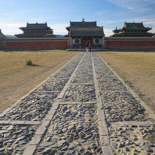 A long stone path leads to a walled area.