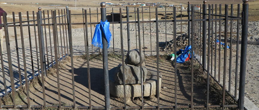 A large stone penis surrounded by a metal cage.