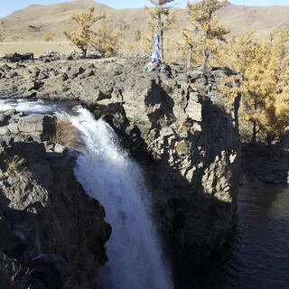 A foaming waterfall plunges down a rock face.