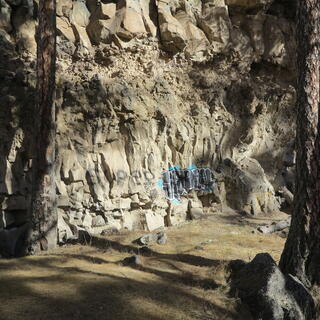 Spray painted graffiti on a natural rock wall.