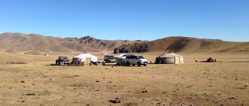 A handful of ger tents and vehicles.