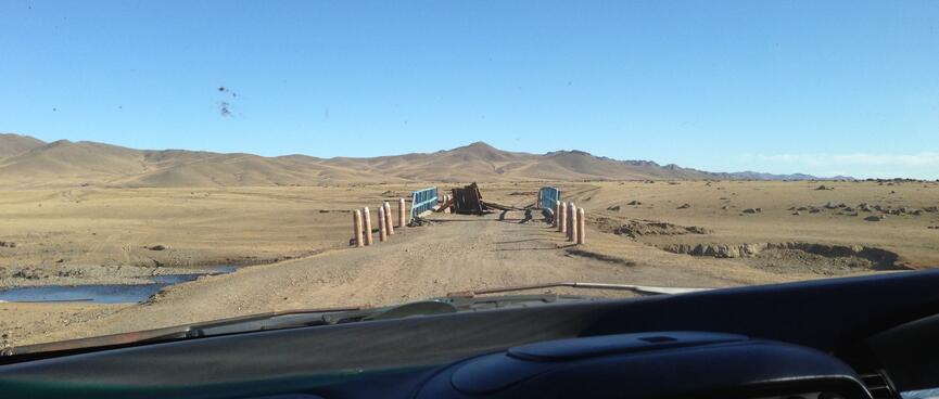 A collapsed bridge blocks the road ahead.