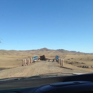 A collapsed bridge blocks the road ahead.