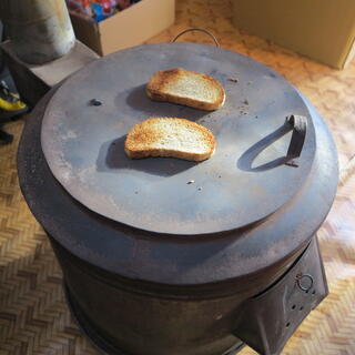 Two pieces of toast sit on top of a round metal stove top.