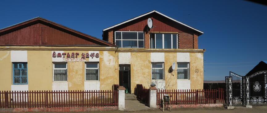 A brown and yellow building with white stripes over the windows.