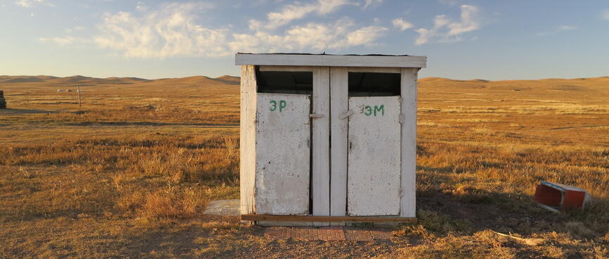 A white wooden shed with two doors.